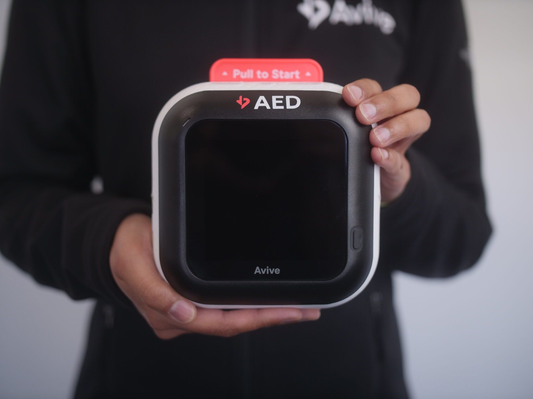 Person holding new Avive AED unit